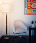 Lucas LED Floor Lamp With Drum Shade And Warm Wood Finish next to armchair in a modern living room setting