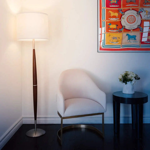 Lucas LED Floor Lamp With Drum Shade And Warm Wood Finish next to armchair in a modern living room setting