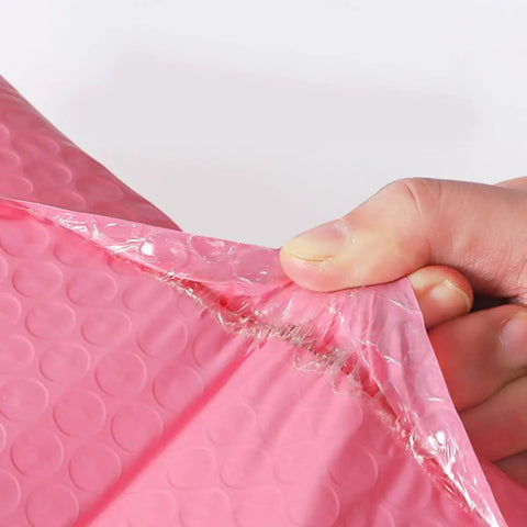 Close-up of tear-resistant Pink Bubble Mailers 100 Pack 12x18 Plus 4 Inch Thickened Padded Envelopes Self Seal being opened