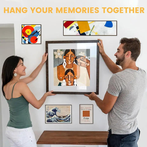 Couple using Sixty Piece Premium Sawtooth Picture Hangers With Matching Wall Screws And Utility Bag to install artwork.