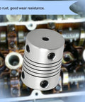 2 Pack Flexible Beam Couplings 4mm To 8mm Shaft, 19mm Outer Diameter, 25mm Length, M4 Screws, shown with engine parts