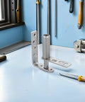 Stainless Steel Double Swing Door Hinges With Self-Closing Spring Load For 16mm-20mm Doors, displayed on a workshop table.