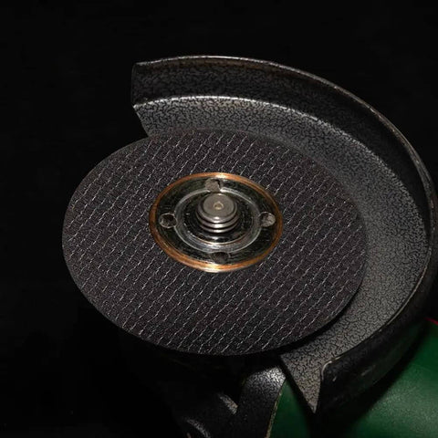 Cutting disc from Six Piece Cut Off Wheel Set With One Quarter Inch Stem For Die Grinder, mounted on tool, black reinforced with fiberglass