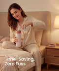 A woman in pajamas pouring water into a Portable Stainless Steel Breast Milk Chiller, ideal for storing milk.