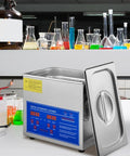 Front view of a stainless steel ultrasonic cleaner with blue digital control panel and open lid on lab bench.