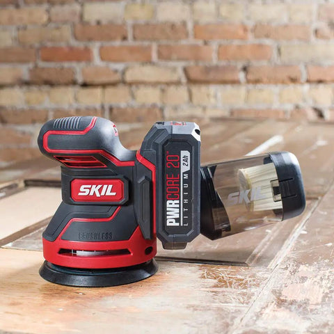 PWRCore 20 Brushless 20V 5-Inch Random Orbital Sander with 2.0Ah Battery and PWRJump Charger on wood surface