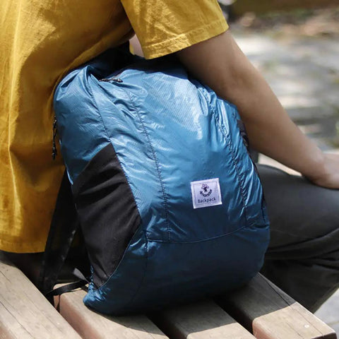 Ultra Lightweight Water Resistant Packable Go To Hiking Daypack for Travel and Outdoor Adventures 16L Blue Backpack on a bench