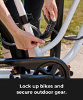 Person securing bike with Bike Cable Lock 6 Feet By Half Inch With Resettable Four Digit Combination and Black Vinyl Coating.
