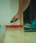 Person applying epoxy floor wearing Spiked Shoes For Resinous Epoxy Floor Coatings With Replaceable Spikes Slip On Quick Fit