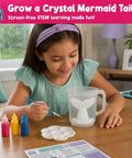Mermaid Crystal Growing Kit For Kids 6 To 8, STEM Craft Toy That Grows Sparkling Crystals On A Mermaid Tail, Totally Screen-Free, Hands-On Science And Art Project For Young Scientists. Girl painting mermaid tail kit with crystal powder, paints, and tray