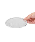 Hand holding Aluminum 6 Inch Pizza Screen Pack Of 144 For Crispy Crust And Fast Even Baking Lightweight And Stackable With Seamless Rim