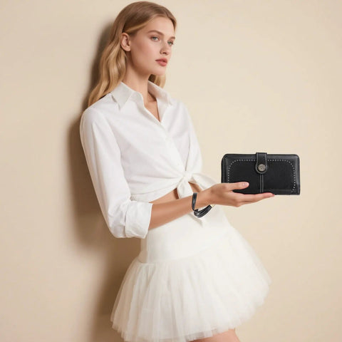 Lux Waxed Leather Wallet For Women With RFID Blocking Large Bifold Card Holder And Wristlet Clutch in black held by woman in white dress