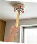 Hand using Slick Aluminum Alloy Ceiling Smoke Detector Puller With Heavy Duty Claw Head on a ceiling smoke detector.
