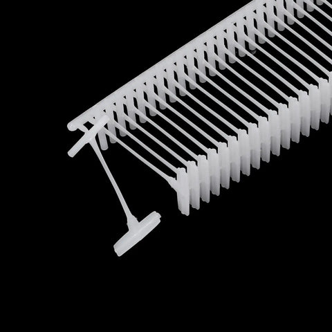 Top Rated 5000 Piece Plastic Tagging Gun Fasteners 0.5 Inch White Barbs That Lock Tight On Clothing And Retail Items Smooth Sailing With Wide Paddle Tips No Fuss Garment Label Refills in a close-up view showing durable white plastic barbs.