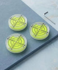SILENRADAWN Small Circular Bubble Levels 3 Piece Round Spirit Level Layout on gray surface with clear yellow liquid.