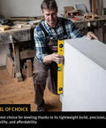 Man using 48 Inch Heavy Duty Aluminum Spirit Level Featuring Dead On Accuracy on a white panel in a workshop.