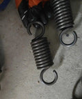 Industrial Grade Heavy Duty Steel Extension Spring Built For Hardcore Diy Mechanics And Auto Shops Featuring Thick Gauge Wire Coils With Locking Hook Ends Zero Fuss Design To Handle Serious Tension Loads Daily held in a gloved hand.