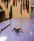 Automatic Aerosol Fire Extinguisher For Vehicle Engines And Auto Spaces on a workbench in a garage setting.