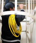 Heavy Duty Outdoor Extension Cord For Yard And Jobsite Use 15 Amp 1875 Watt Capacity Bright Yellow Jacket coiled on shoulder