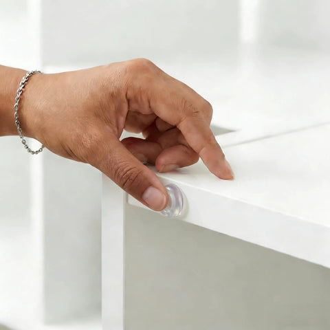 User applying a clear silicone cabinet door bumper from the Straight Up Solid 164 Piece Pack for furniture protection.
