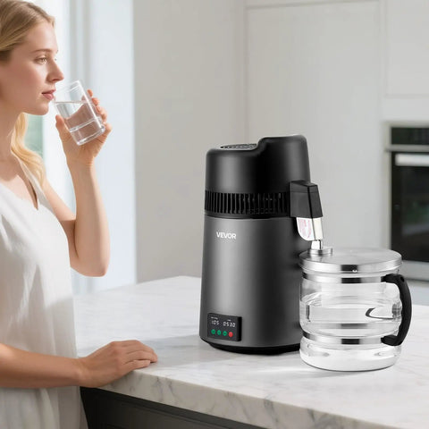 Smooth Sippin Water Distiller With Built Tough Stainless Core And Crystal Clear Glass Pot in kitchen with glass of water.