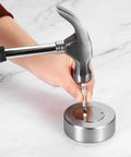 Steel bench block with hammer and punch shown; round silver base, no holes.