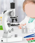 Child using High Power 200X to 4800X LED Monocular Microscope With Slides Set for Adults and Students Ideal for School Labs Homeschool and Hands On Science Projects, with lab equipment.