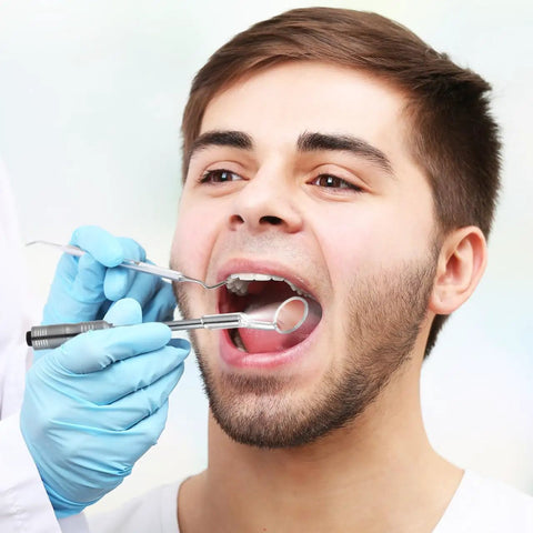 Dentist using LED Lighted Stainless Steel Mouth Mirror For Teeth Inspection And Plaque Removal during a dental exam.