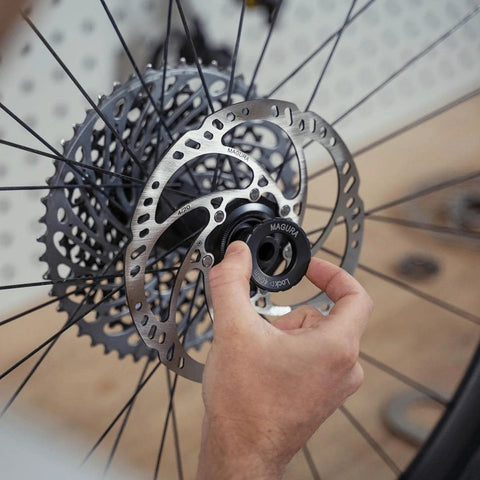 Magura MDR-C 203mm brake rotor; silver perforated disc with black center-lock ring (close-up view).