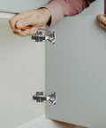 heavy duty cabinet door hinges being installed on white cupboard