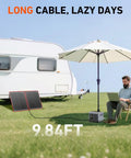 100W Portable Foldable Solar Panel Kit With Separate Controller And Dual USB for RVs Vans Tents shown charging near RV in field