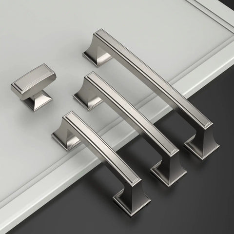 Image showing a variety of metallic cabinet handles on a flat surface.