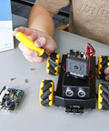 AI robot kit for STEM education with mecanum wheels and ESP32 camera being assembled on a table, ideal for hands-on learning projects.