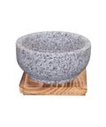 Granite Stone Bowl With Wooden Base For Bibimbap And Korean Stews, shown on wooden tray, side angle view, 24oz size.