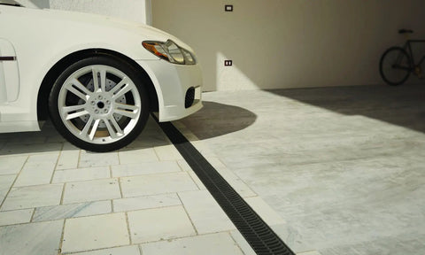 Pro Grade Trench Drain Kit With Black Grate, 9.84 Ft Total Length installed in driveway beside car