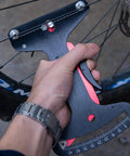 Person using Road And MTB Spoke Tension Gauge Pro Grade Aluminum Alloy Bike Wheel Truing Tool for spoke tension checks.