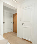Interior view of a hallway featuring two white doors with Bombproof Heavy Duty Ball Bearing Door Hinges In Matte Black Finish.