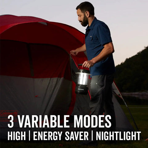 Person holding Ultra Bright LED Camping Lantern With 300 Lumens Battery Powered Water Resistant Emergency Light near red tent