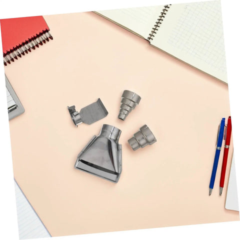 High Grade Stainless Steel Heat Gun Nozzle Set For Plastic Welding And Shrink Wrap Repair With Easy Swap Design and Energy Efficient Airflow laid out on a desk.