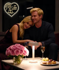 Couple relaxing with romantic lighting and a heart-shaped 'Happy Wedding Anniversary' neon sign in the background.
