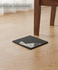 Self-Adhesive EVA Furniture Leg Pads For Floor Protection, Black Cushioning Glides shown under wooden chair leg on hardwood floor