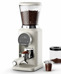 Next Level Electric Burr Coffee Grinder With 34 Dead Simple Settings And 40 Millimeter Stainless Steel Conical Burrs For Smooth Daily Brews In Clean White Setup, showing coffee beans and ground coffee.