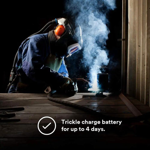 Welder using Smart Lithium Ion Battery Charger for Adflo PAPR Welding Rig with Speedglas Helmets in dim workspace, 35-0099-08 Pro