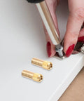 Installing Brass Shelf Pins Set, 4 Pack U Shaped Support Pegs For Cabinets And Wardrobes with screwdriver, close-up view