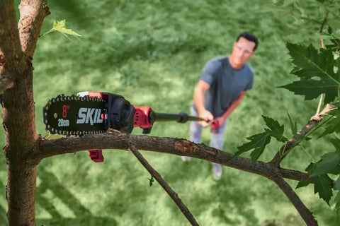 Solid Build Cordless Pole Saw With Eight Inch Bar And Ten Foot Reach To Clear High Limbs Like A Pro cutting through tree branches.