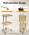 Gold stainless steel salon rolling cart with wheels, two trays folded, Stainless Steel Salon Rolling Cart Two Tier With Durable Wheels For Hair Studio Equipment, Pro Grade Mobile Storage Cart, Heavy Duty Stainless Steel Trolley For Tools, Supplies, And Salons