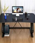 Heavy Duty Gaming Desk With Ergonomic Arch And Handy Phone Dock, Slick Waterproof Top, Space Savvy Silhouette, Zero Hassle Setup, Built For Late Night Streams Or Remote Grinds, Matte Black, viewed from above with monitor and accessories.