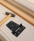 Heavy Duty Furniture Hinges Set in Black Carbon Steel with Screws Gate and Shed Door Hinges beside hammer and wood piece