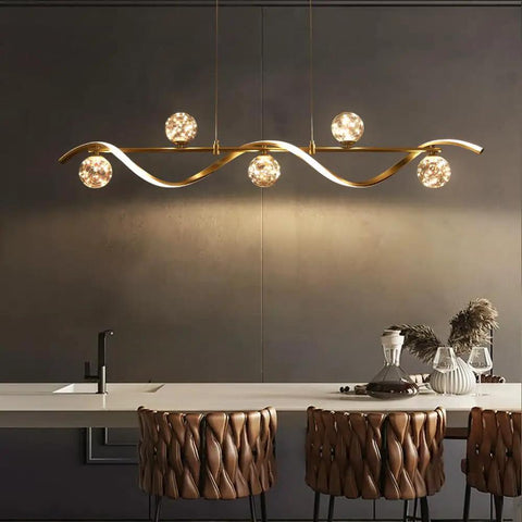 Modern Linear Pendant Light Set Featuring Six Glass Globe Shades Dimmable Gold Kitchen Island Fixture illuminating a sleek dining space.