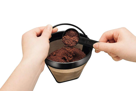 Hands scooping coffee grounds into Gold Tone Permanent Coffee Filter For 12 Cup Coffee Makers Including Krups Savoy Braun DeLonghi
